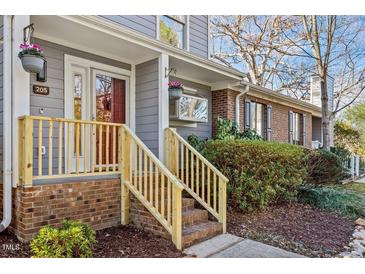 Charming front porch with brick steps, flowerpots, and newly renovated wooden handrail and post at 205 Clancy Cir, Cary, NC 27511