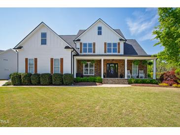 Charming two-story home with inviting front porch and beautifully landscaped front yard at 222 Friesan Way, Rolesville, NC 27571