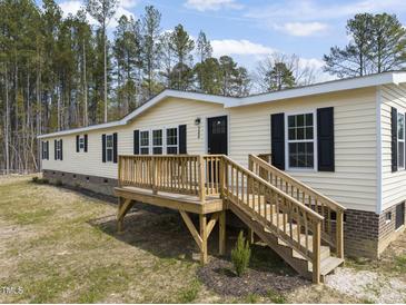 Charming yellow home with a wooden deck and black shutters, nestled among tall trees at 248 Dutches Ln, Henderson, NC 27537