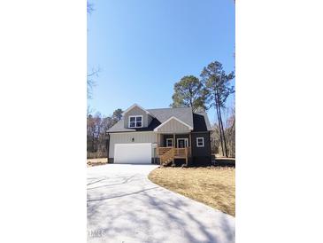 Charming two-story home with a welcoming front porch and a spacious driveway, perfect for a growing Gathering at 307 7Th St, Butner, NC 27509