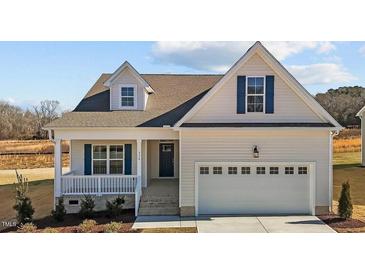 Charming home featuring white siding, blue shutters, and an attached two-car garage at 336 Pecan Valley Way, Four Oaks, NC 27524
