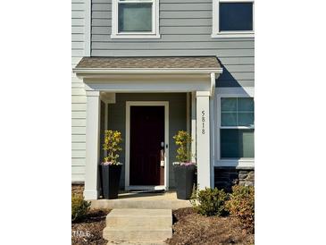 Charming home entrance with a decorative door, potted plants, and craftsman-style architecture at 5818 Humanity Ln, Raleigh, NC 27616