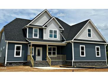 Charming two-story home featuring gray siding, white trim, covered front porch, and black shingle roof at 70 Prency Ln, Middlesex, NC 27557