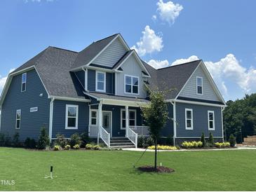 Charming two-story home featuring a manicured lawn, blue siding, and a welcoming front porch at 70 Prency Ln, Middlesex, NC 27557