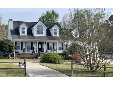 Charming two-story home with black shutters, white trim, and manicured lawn at 100 Blackberry Creek Dr, Willow Springs, NC 27592