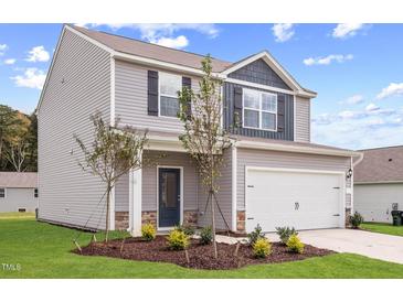 Charming two-story home with a well-manicured lawn and a two-car garage, enhanced by tasteful landscaping at 110 Rhino Bnd, Oxford, NC 27565