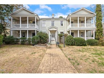 Charming brick townhouse with dual covered front porches and a welcoming walkway to the front door at 1115 Wake Forest Rd # B, Raleigh, NC 27604