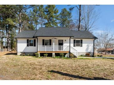 Charming home featuring a cozy front porch, dark shutters, and a well-maintained yard at 120 W College St, Oxford, NC 27565
