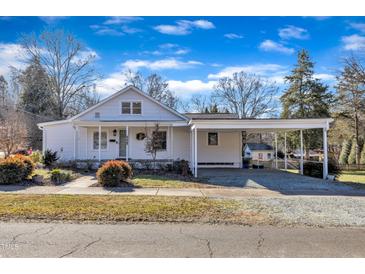 Charming single-story home with a covered porch and carport, set against a bright blue sky at 152 E Tryon St, Hillsborough, NC 27278
