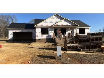 Under construction home featuring brick accents, a covered porch, and an attached two-car garage at 186 N Movado Trl, Kenly, NC 27542