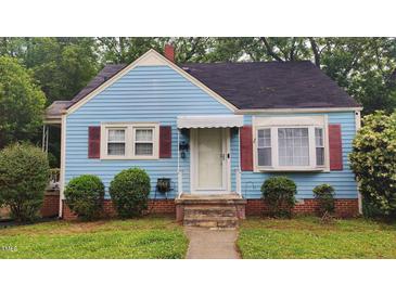 Charming blue home featuring red shutters, a brick foundation, and a well-maintained front yard at 214 Grace St, Oxford, NC 27565