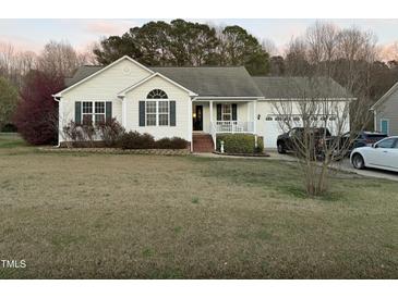 Charming single-story home featuring a well-maintained lawn, attached garage, and inviting front porch at 254 Pedernales Dr, Smithfield, NC 27577