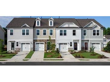Row of new construction townhomes featuring individual garages and neutral color palettes at 276 Hank Way, Angier, NC 27501