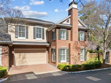 Charming two-story brick home with attached garage, green shutters, and well-maintained landscaping at 2820 Glenwood Gardens Ln # 101, Raleigh, NC 27608