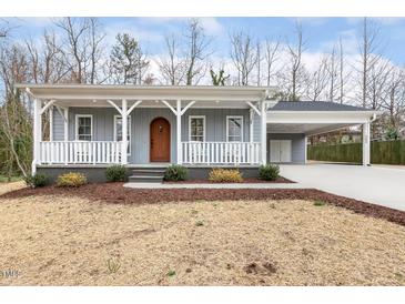 Beautiful light blue home featuring a covered porch and convenient side carport at 3650 Durwood Ln, Raleigh, NC 27604