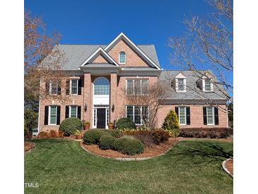 Charming two-story brick home with a manicured front lawn and mature landscaping at 3708 Wesley Ridge Dr, Apex, NC 27539