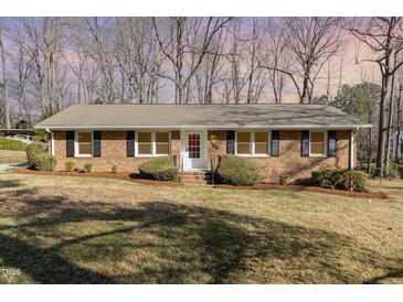 Charming single-story brick home featuring black shutters and a well-manicured front yard at 4508 Regis Ave, Durham, NC 27705