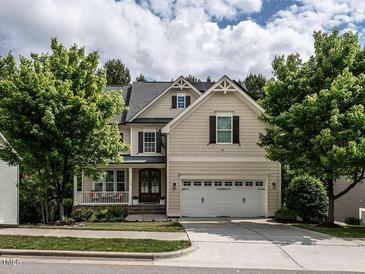 Beautiful two-story home with a well-manicured lawn, mature trees, and an attached two-car garage at 730 Toms Creek Rd, Cary, NC 27519