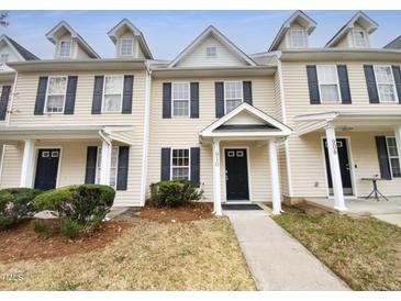 Inviting townhouse with blue shutters, a black door and small front yard at 910 Savin Lndg, Knightdale, NC 27545
