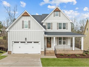 Charming two-story home features a welcoming front porch and a two-car garage at 112 Pointe Park Cir, Holly Springs, NC 27540
