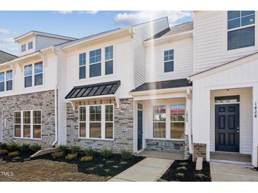 Charming townhome showcasing white siding, stone accents, and an inviting entrance at 1426 Cooper St, Sanford, NC 27330