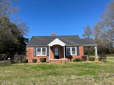 Charming one-story red brick home with a welcoming front porch and well-manicured lawn at 148 Baptist Church Rd, Henderson, NC 27537