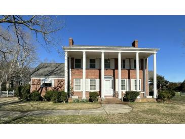 Stately brick home featuring prominent white columns and shutters for an elegant, classic look at 2200 N Nc 49 Hwy, Burlington, NC 27217