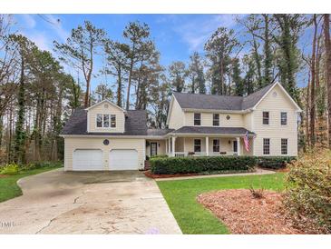 Charming two-story home with a welcoming front porch, manicured lawn, and an attached two-car garage at 3101 Rutledge Ct, Raleigh, NC 27613