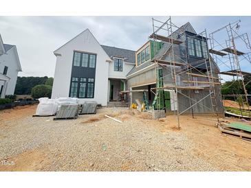 Two story home with white stucco and black trim and window frames under construction at 3405 Makers Circle, Raleigh, NC 27612