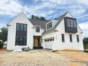 Stunning new construction home with a white facade, black windows, and modern architectural details at 3405 Makers Circle, Raleigh, NC 27612