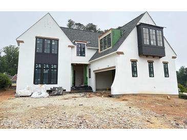 Striking new construction home featuring a white stucco exterior, black window frames, and a modern architectural design at 3405 Makers Circle, Raleigh, NC 27612