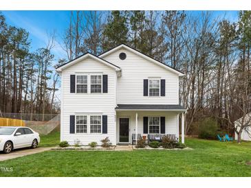 Charming two-story home with white siding, black shutters, and a well-maintained front lawn at 6923 Fox Haven Pl, Raleigh, NC 27616