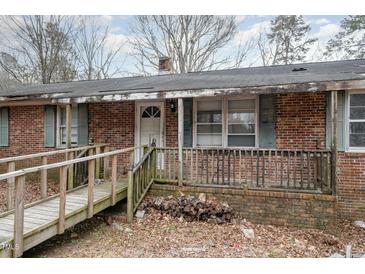 Exterior brick home featuring a front porch and wooden ramp at 1066 Shuford Rd, Wake Forest, NC 27587