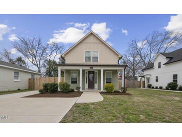 Charming two-story home with green siding, a covered porch, and a well-manicured lawn at 1105 Massey St, Smithfield, NC 27577