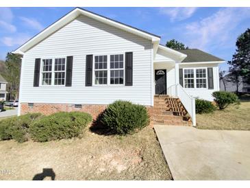 Charming single-story home with white siding, black shutters, and landscaped front yard at 13 Herndon Ct, Clayton, NC 27520