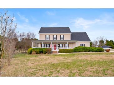 Charming two-story home featuring a welcoming front porch with white railings and a well-maintained lawn at 170 Blande Dr, Kenly, NC 27542
