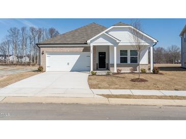 Charming single-story home featuring a brick facade, white siding, and an attached two-car garage at 185 White Birch Ln, Angier, NC 27501