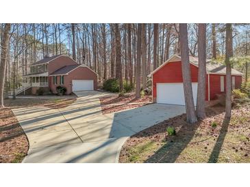 View of the home's exterior with an attached garage and a detached garage, both with large driveways at 2501 Huntsman Trl, Zebulon, NC 27597