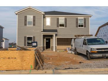 New two-story home featuring gray siding, an attached garage, and a welcoming front entrance at 3405 Rosebush Dr, Zebulon, NC 27597