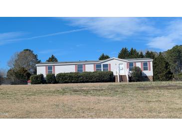 Charming single-story home with blue siding, red trim, and mature landscaping under a clear blue sky at 4600 Strawbush Rd, Spring Hope, NC 27882
