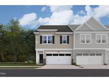 Charming townhome with attached garage and a blend of stone and siding accents under a sunny sky at 6968 Doddridge Ln # 11, Cary, NC 27519