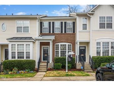 Charming townhome featuring a brick facade, black shutters, and a well-manicured front yard at 7753 Winners Edge St, Raleigh, NC 27617