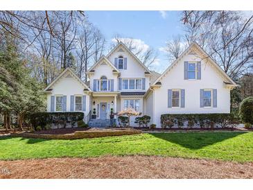 Stately white brick home with manicured lawn and detailed blue shutters at 9700 Pentland Ct, Raleigh, NC 27614