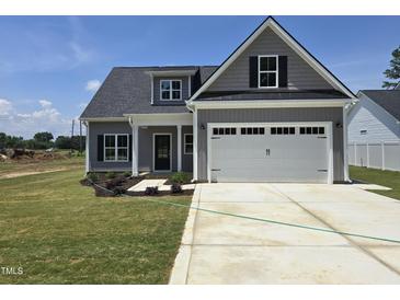 Charming single-Gathering home with gray siding, white garage door, and manicured lawn at 1039 N Lincoln St, Benson, NC 27504