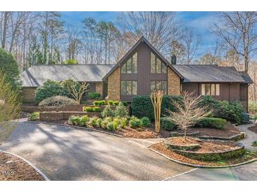 Charming home featuring stone and wood exterior, surrounded by lush landscaping and mature trees at 10729 Trego Trl, Raleigh, NC 27614