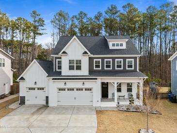 Charming two-story home boasts a three-car garage, gray roof, and landscaped front yard at 110 Jacoby Way, Chapel Hill, NC 27516