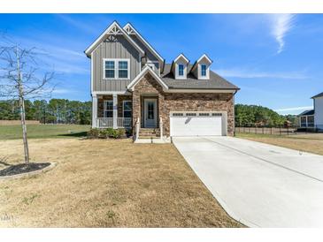 Beautiful two-story home featuring stone and gray wood, attached two-car garage, and a well-manicured front yard at 125 Scotland Dr, Youngsville, NC 27596