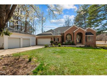 Inviting brick home with a manicured lawn and separate garage, offers classic charm and convenience at 199 Black Cloud Dr, Louisburg, NC 27549