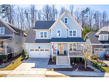 Charming light-blue two-story home featuring a welcoming front porch and attached two-car garage at 201 Bluffwood Avenue, Chapel Hill, NC 27516