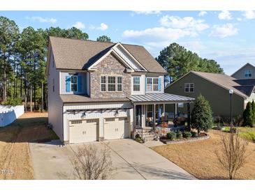 Charming two-story home featuring stone accents, a covered porch, and a two-car garage at 253 Bendemeer Ln, Rolesville, NC 27571